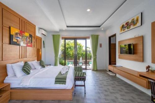 ein Schlafzimmer mit einem großen Bett und einem Fernseher in der Unterkunft Villa Rama Penida by ABM in Toyapakeh