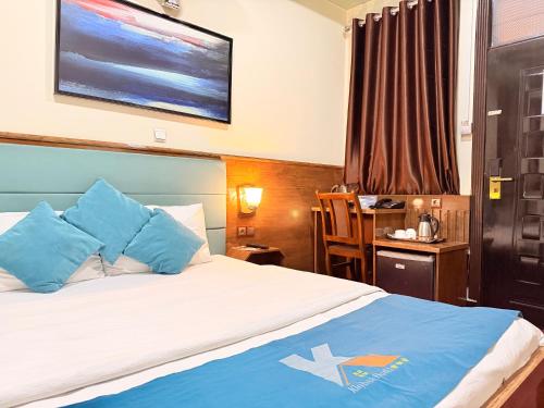 a bedroom with a bed with blue pillows and a desk at Khyber Hotel in Kabul