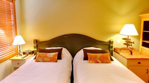 Un dormitorio con dos camas con sábanas blancas y almohadas naranjas. en Embarc Panorama, en Panorama