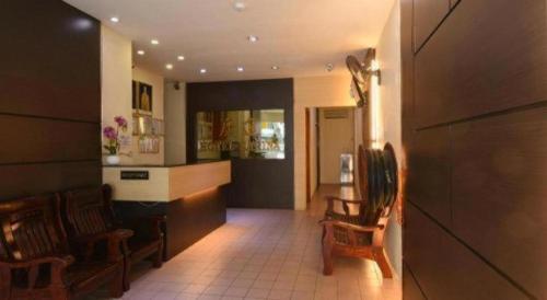 ein Wohnzimmer mit zwei Stühlen und eine Küche in der Unterkunft Hotel Sarina in Mukah