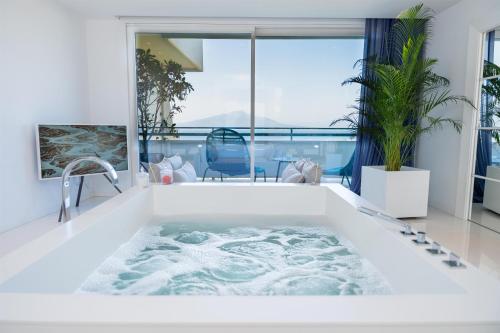 a bathtub in a bathroom with a view at Hilton Sorrento Palace in Sorrento