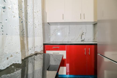 Una cocina roja y blanca con un gabinete rojo. en Theodoros Kolokotronis - Alkyoni, en Nauplia