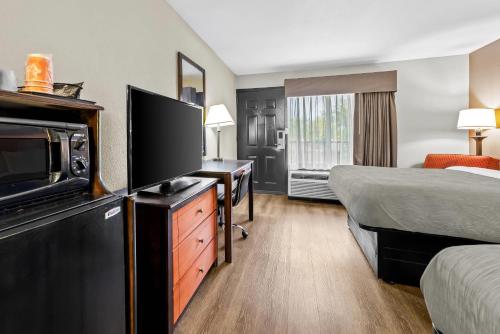 a hotel room with a television and a bed at Quality Inn Richland - Jackson South in Richland