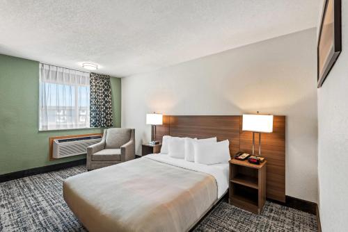 ein Hotelzimmer mit einem Bett und einem Stuhl in der Unterkunft Quality Inn in West Des Moines