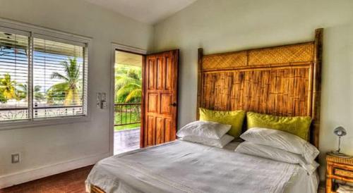 a bedroom with a large bed and a large window at Iguana Lodge Beach Resort in Puerto Jiménez