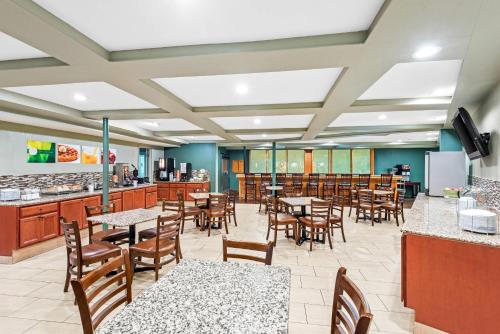 a restaurant with tables and chairs and a kitchen at Quality Inn West Des Moines - Clive in West Des Moines