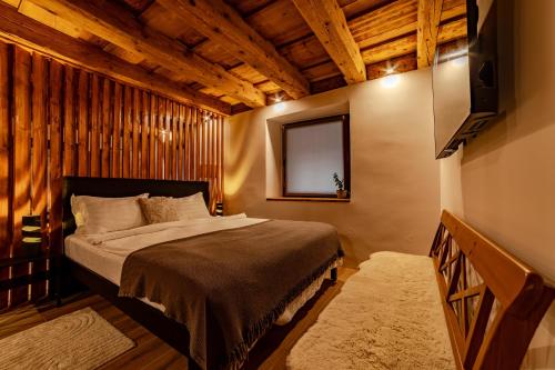 Un dormitorio con una cama y un televisor de pantalla plana. en ALBERT RESIDENCE Brasov Historical City Center, en Brasov