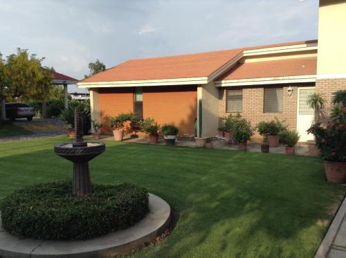 a house with a yard with a fountain in front of it at La Casita de Fraida in Guadalajara
