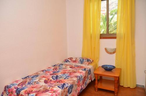 una camera con letto e finestra con tende gialle di Apt. Stella Playa a Valle Gran Rey