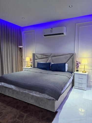 Un dormitorio con una cama grande con paredes moradas. en رويال دايموند, en Al-Hasa