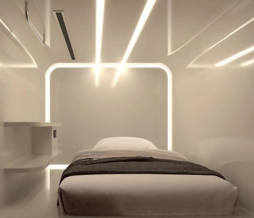 a white room with a bed with lights on it at The Rich Cafe & Hostel in Pattaya South
