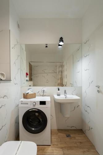 a bathroom with a washing machine and a sink at Sika Jolly Apartment - cazare Arad - self check-in in Arad