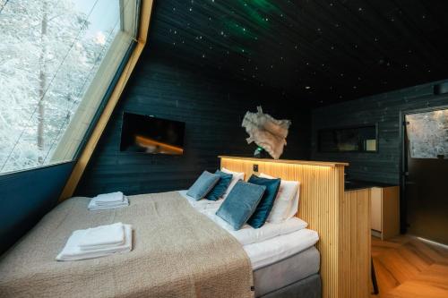 a bedroom with a large bed with blue walls at Lapland Glow Chalets in Rovaniemi