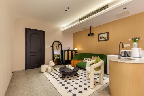 a living room with a green couch and a table at Skyline Riverview Apartments in Chongqing
