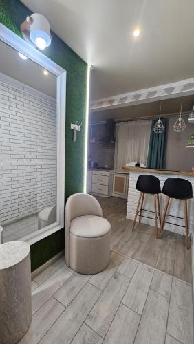 a kitchen with a tub and two chairs and a table at Danyla Galytskogo apartment Центр міста, старе місто 5хв in Kamianets-Podilskyi