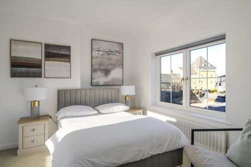 a bedroom with a bed and a large window at Luxurious 3 Bed House with Free Parking, Sky TV, Movies & Netflix in Braintree