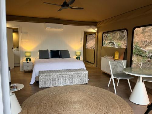 a bedroom with a bed and a table at King Safari Tent 5 in Nelly Bay