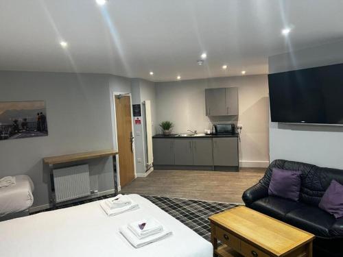 ein Wohnzimmer mit Sofa und eine Küche in der Unterkunft Crown Hotel & Bar in Inverness
