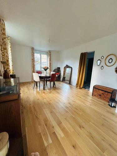 sala de estar con suelo de madera y mesa en Maison à la Campagne, 