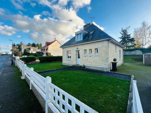 una valla blanca delante de una casa en Maison à la Campagne, 
