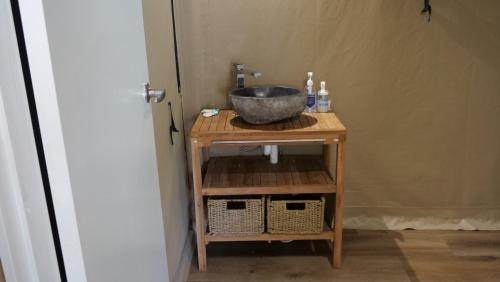 a bathroom with a sink on a wooden table at King Safari Tent 5 in Nelly Bay