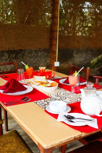 a table with red napkins and plates on it at Sky Villa Unawatuna in Unawatuna