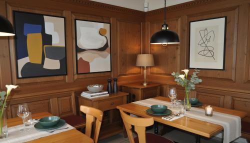 a dining room with a table and chairs and paintings at Hotel Sternen in Gurtnellen