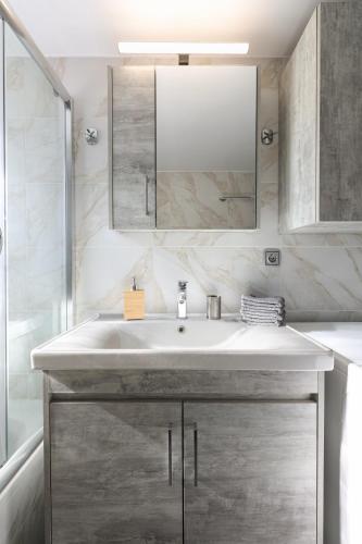 a bathroom with a white sink and a mirror at Villa Cicada Chania, Steps from the beach, Car included in Agia Marina Nea Kydonias