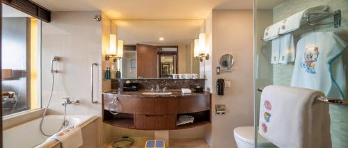 a bathroom with a sink and a toilet and a mirror at Crowne Plaza Kunming City Centre by IHG in Kunming
