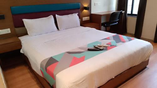 ムンバイにあるHotel AI inの大きなベッド(靴付)が備わるホテルルームです。