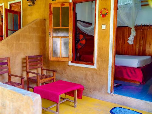 a room with two chairs and a bed and a window at Udawalawe Safari House in Udawalawe
