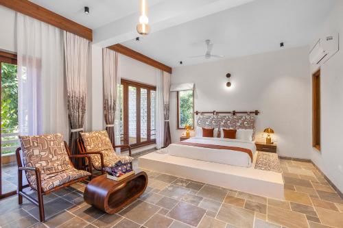 ein Schlafzimmer mit einem großen Bett und einem Stuhl in der Unterkunft Viresco by Alaya Stays in Thūr