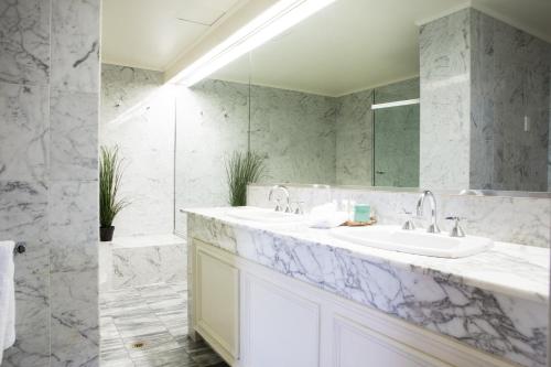 a bathroom with two sinks and a mirror at Hotel Richmond on Rundle Mall in Adelaide