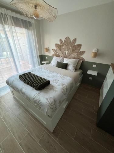 ein Schlafzimmer mit einem Bett mit einem großen Blumenkopfteil in der Unterkunft La Barrique Champenoise - Studio and Terrasse in Tours-sur-Marne