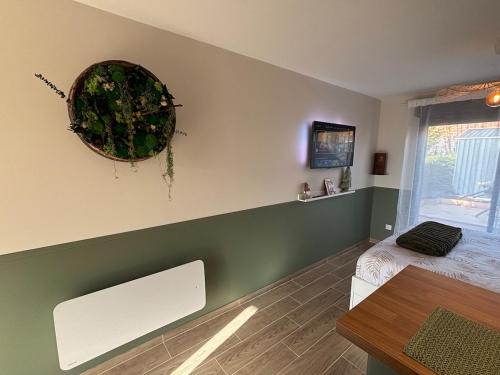 ein Schlafzimmer mit einem Bett und einem Kranz an der Wand in der Unterkunft La Barrique Champenoise - Studio and Terrasse in Tours-sur-Marne