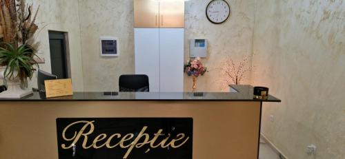 a reception desk in a room with a clock on the wall at Complex Lebada Botosani in Botoşani
