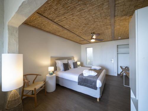 ein Schlafzimmer mit einem Bett, einem Tisch und einem Stuhl in der Unterkunft Hotel Punta Lara Noirmoutier in La Guérinière