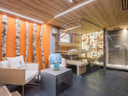 een kamer met oranje muren en een stoel en een tafel bij Chalet CLADIE - Private Jacuzzi & Sauna - View of Mont Blanc range - By Cozee Rentals in Les Houches