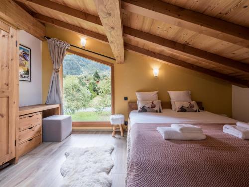 twee bedden in een kamer met een groot raam bij Chalet CLADIE - Private Jacuzzi & Sauna - View of Mont Blanc range - By Cozee Rentals in Les Houches