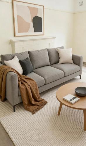 a living room with a gray couch and a table at Quiet Guest Room in Burwood in Sydney