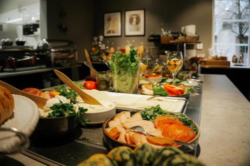 una línea de buffet con tazones de comida en un mostrador en Hotell Boras, BW Signature Collection, en Borås