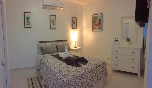 a bedroom with a bed and a dresser and a lamp at Batey Hotel Boutique in Boca Chica