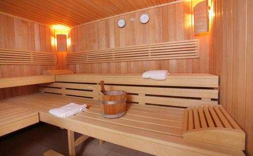 Beaune Levernois - Piscine Chauffée, Sauna et Golf في ليفيرنوا: ساونا خشبية بها مقعدان ومنشفتان