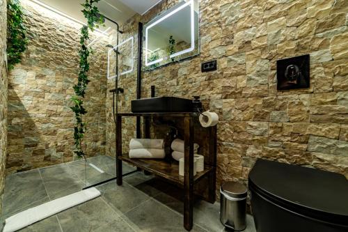 a bathroom with a stone wall at ALBERT RESIDENCE City Center Accommodation Brașov in Braşov