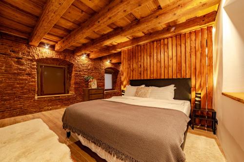 a bedroom with a bed and a brick wall at ALBERT RESIDENCE City Center Accommodation Brașov in Braşov