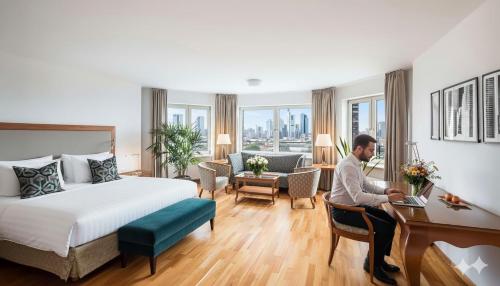 a man sitting at a desk in a hotel room at Main Plaza Suite Tower in Frankfurt/Main