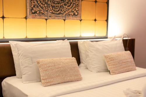 The Beach Residence Kata في شاطئ كاتا: سرير بمخدات بيضاء وطاولة للرأس