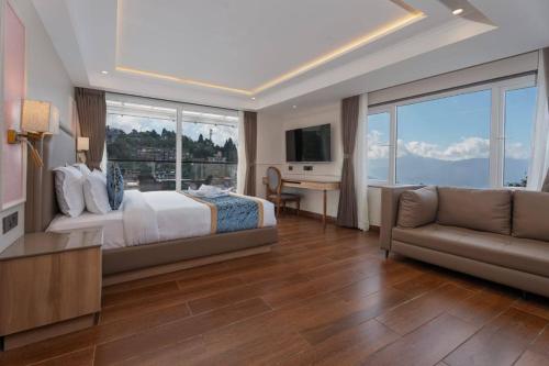 Hotel Tenzing's Glory Darjeeling في دارجيلنغ: غرفة نوم بها سرير ومكتب وأريكة