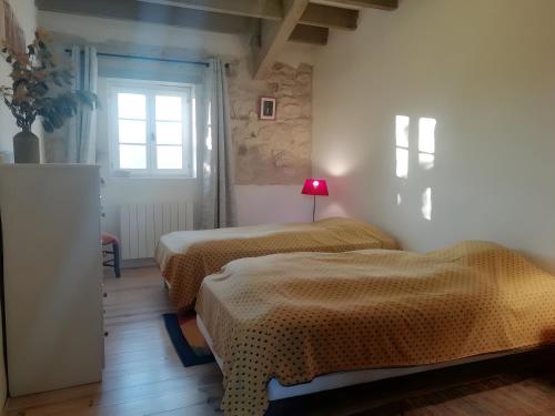 een slaapkamer met twee bedden en een raam bij Gite Laurélie, Un Écrin De Sérénité in Trémons