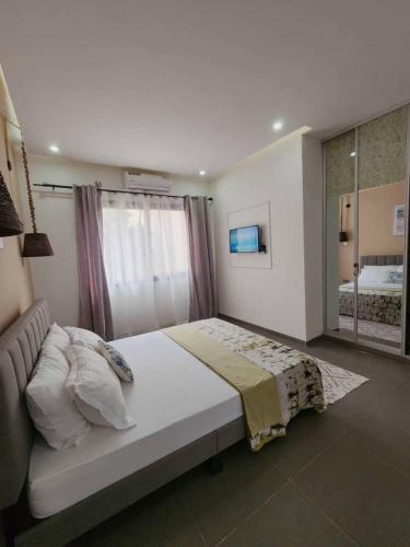 a bedroom with a large bed and a large window at La Trêve Sacrée - Dakar mermoz sacrée cœur in Dakar